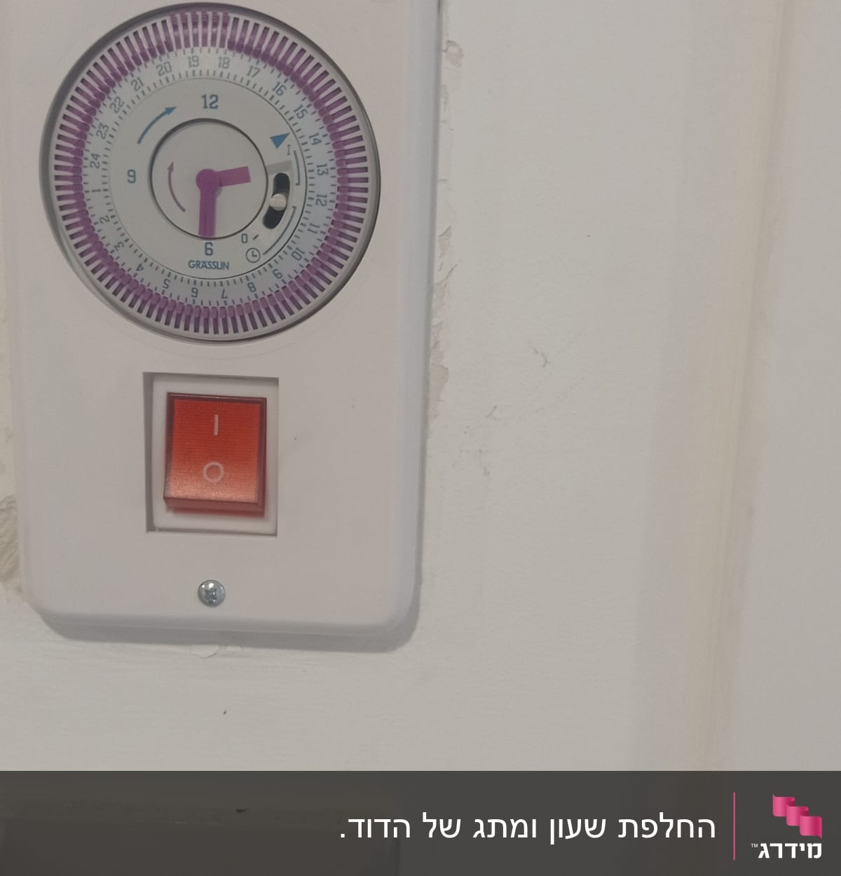 שעון טיימר חשמלי ומתג הפעלה על קיר